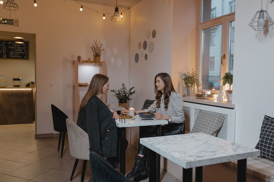 Two friends enjoying a delicious vegan lunch in a stylish, cozy cafe setting.